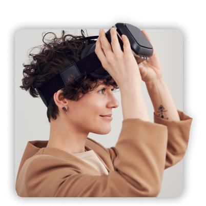 Woman smiling while putting on a VR headset.