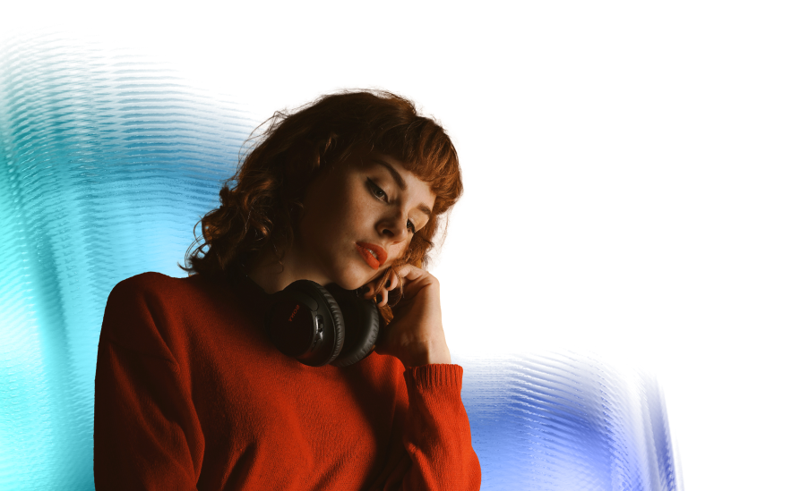 A woman with red hair and headphones around her neck.